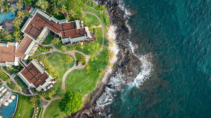 Bird's eye view of beachfront vacation homes and condos along coastal landscape in Wailea-Makena Maui Hawaii during golden hour sunset