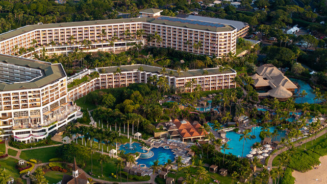 Panoramic aerial view of Grand Wailea beachfront resort along coastal landscape in Wailea-Makena Maui Hawaii during golden hour sunset