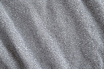 close-up of soft gray woven textile with pebble weave and gentle diagonal folds conveying a calm cozy texture