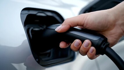 Charging Electric Car, Hand Holding Plug, Close-up, Sustainable Energy