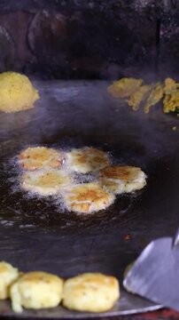 Tikki an indian street food being fried in oil on a pan