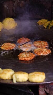 Tikki an indian street food being fried in oil on a pan