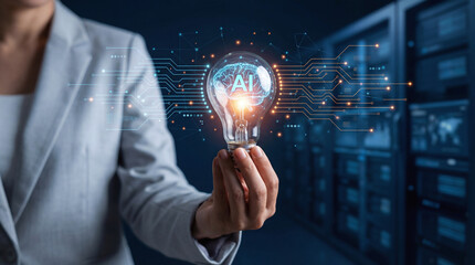 AI Artificial Intelligence concept with glowing lightbulb held by business person in a high-tech data center.