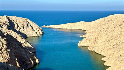 Fototapeta premium Bay Mouth Opening To Blue Sea, Gentle Tidal Flow Between Sandstone Cliffs With Azure Water Meeting Horizon, Calm Reflection And Navigation Potential For Coastal Survey And Maritime Lifestyle Visuals