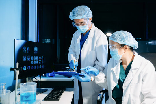 Medical scientists conducting laboratory research using digital tools and lab equipment. Healthcare, biotechnology, diagnostics, and clinical research teamwork concept.