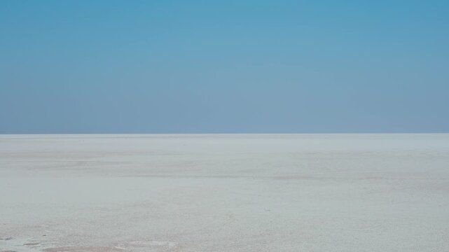 4K Landscape shot of the Rann of Kutch desert during the day with clear sky as seen during the sunny day at Kutch in Gujarat, India. Scenic desert afternoon background. White desert during day. 