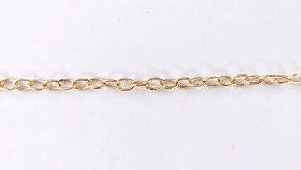 Single straight horizontal gold cable chain line on white surface.