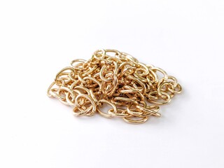 Pile of gold cable chain links on white background high angle.