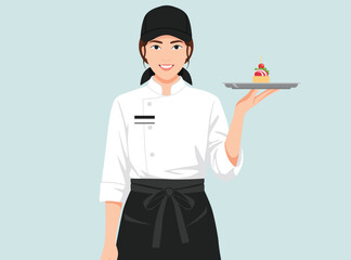 Smiling female pastry chef or waitress or server in uniform, wearing a black cap holding a small decorative dessert on a silver tray