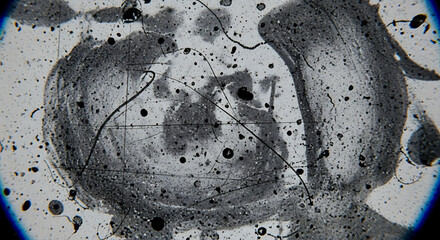 Close-up view of a gray and white abstract design with splatters and circular patterns on a surface.