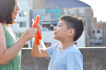 Happy latin siblings holding fruit ice.