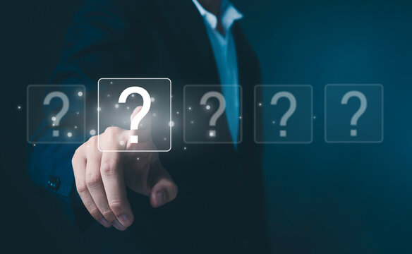 This image symbolizes decision-making and problem-solving in a modern business context. A professional reaches toward a glowing question mark, representing uncertainty, critical thinking.