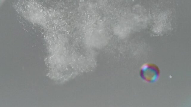 Cloud of fine white powder with a colorful bubble is a dynamic and eyecatching image perfect for artistic and creative projects. Suitable for backgrounds and design elements.