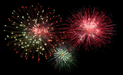 Vibrant bursts of red, green, and yellow fireworks illuminate the night sky, creating a festive and celebratory atmosphere