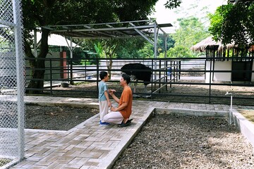 Father sitting with his son in a peaceful outdoor park, encouraging calm moments and emotional connection. Represents mindfulness, sustainable living, and mental wellbeing through nature.