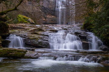 Fototapeta premium A serene view of Suuçtu Waterfall in Bursa, with water cascading over moss-covered rocks, surrounded by lush greenery and trees, creating a peaceful, natural landscape perfect for nature lovers.