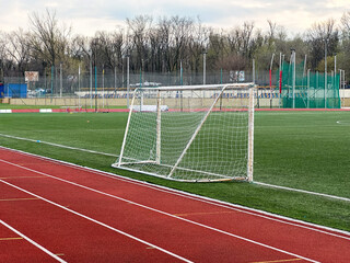 Fototapeta premium An empty soccer field with goalpost and running track.