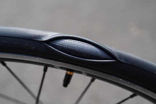 Close up of a damaged bicycle tire with a bulge showing the inner tube image