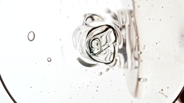 Closeup Shot of Clear Cosmetic Gel Fluid, Essential Oil With Molecule Bubbles Flowing from a Bottle on White Background. Macro Shot of Organic Products, Medicine. Dermatology Science Laboratory. 4k