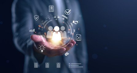 Businessman holding digital icons of people and team management, representing human resources, recruitment, employee data, business leadership, and digital HR solutions.