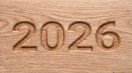 Wooden surface with carved numbers 2026, natural texture and warm tone, symbolizing future, year, or countdown concept with smooth craftsmanship and detailed engraving