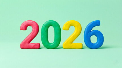 2026 year colorful numbers on green background, bright plastic digits representing future date, vibrant red, green, yellow, blue figures standing in row with soft shadows