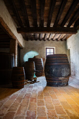 Vintage cellar interior with aged wood textures evokes atmosphere of winemaking history and artisanal dedication.