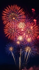 Spectacular fireworks display illuminating the night sky with vibrant bursts of red, orange, and blue, celebrating a joyous occasion