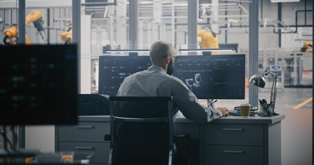 Engineers Monitoring Automation Model. Man Works Intensely at Double Monitor, Where 3D Model Robot...