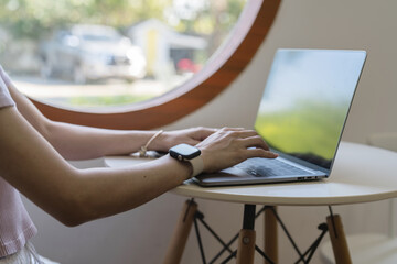 Person using a laptop at a modern workspace with a round window view.