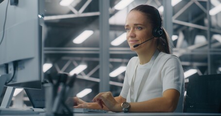 Specialist Manages Network Systems From Workstation in Network Operations Center. Woman Wearing Professional Headset Coordinate Tasks. Proactive System Monitoring and Coordinated Digital Operations.