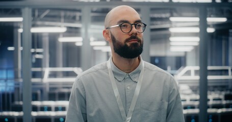 Bearded Male IT Engineer With Glasses, Smiling Confidently While Adjusting Eyewear. Man Standing in...