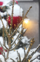 The Christmas tree, decorated with garlands, stands outside; it was snowing.