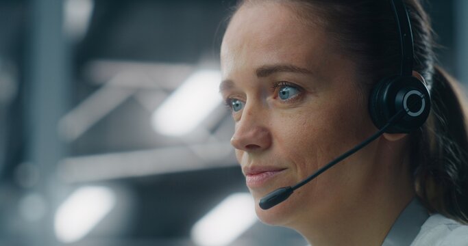 Close Up of Dedicated Female Technician Responding to Real Time System Alerts, Communicating Via Headset at Console in Data Center. Concept of Critical Incident Management and Rapid Response.