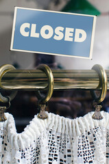 Closed Sign Displayed On Glass Window Over Vintage Brass Rod With White Lace Curtain Decor