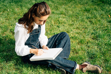 Girl Drawing in Summer Park. Relax lifestyle portrait 