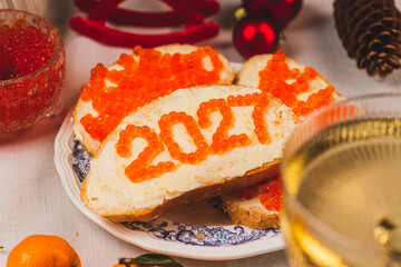 A sandwich with butter and caviar. The figures for 2027 are laid out in dots.