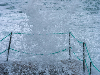 Ocean wave crashing into coastal fence in Cantabria Spain