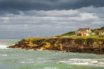 Storm clouds over rugged rocky coastline in Gij&oacute;n Spain