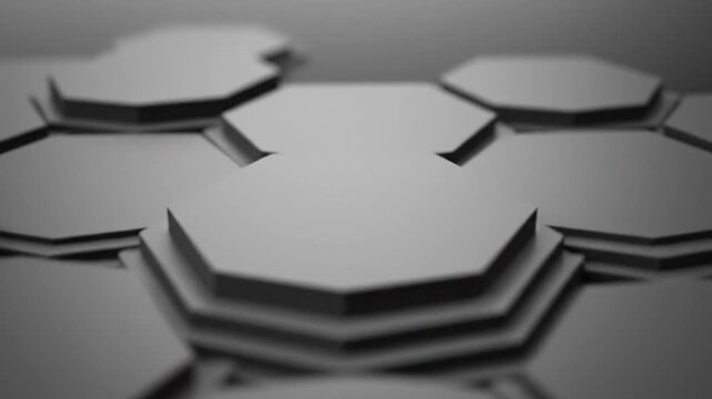 Abstract grayscale 3D render of hexagonal stepped forms arranged with shallow depth of field, futuristic