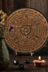 Close-up of a wooden Wheel of the Year engraved with the eight pagan festivals. Spiritual and wicca...