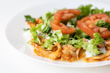 Close-Up of Chicken Kapsalon with Turkish Doner on White Plate