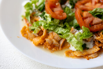 Close-Up of Chicken Kapsalon with Turkish Doner on White Plate