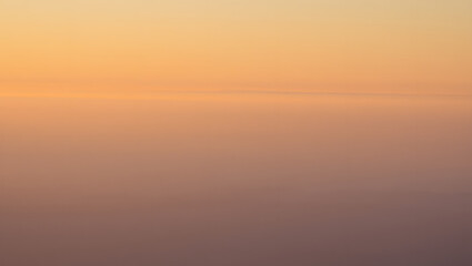 A beautiful orange sunrise and sunset over the sea horizon reflects golden sunlight on ocean waves under a dramatic sky with clouds and natural light at dawn and evening