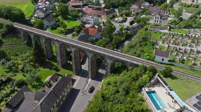Aerial view of old viaduct in Austria. Old railway bridge in cityscape of streets of traditional tourist city.