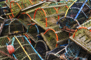 Fishing gear such as traps and pots on display on a harbor wall