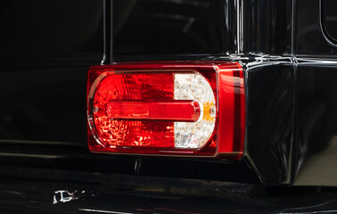 LED taillights of a modern sport car in close-up. Taillight or rear light of modern sport car in street. Close-up view of black sport car rear light. Stylish modern sport car stop signal close up.