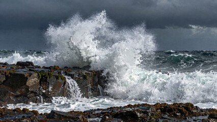 Waves crashing against rocky shore in stormy sea