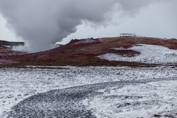 Geothermal steam over snowy volcanic landscape in Reykjanes Peninsula, Iceland.