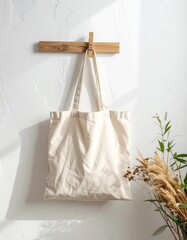 Minimalist Beige Canvas Tote Bag Hanging on a Wooden Hook.
